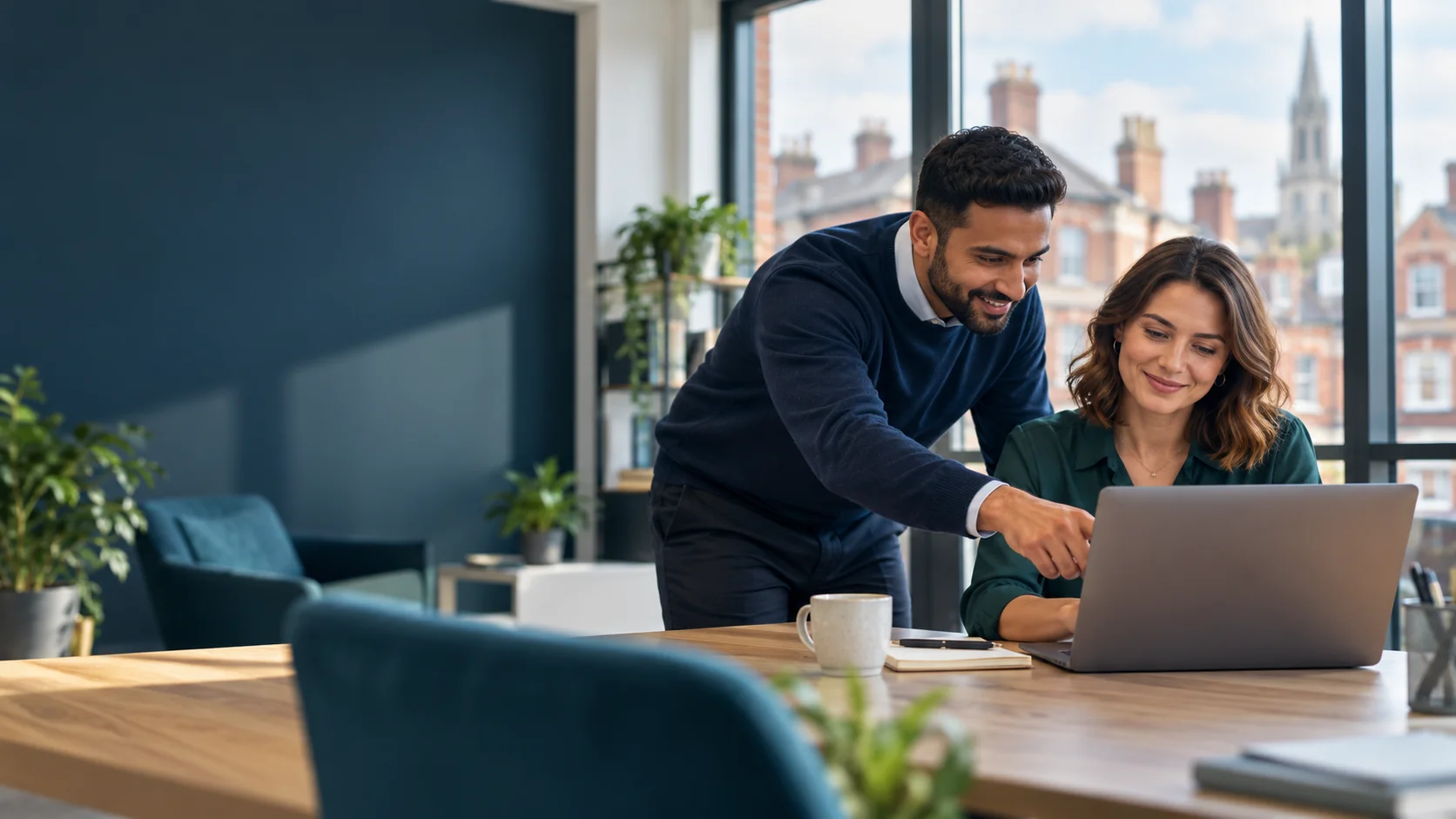 IT consultant helping a business owner use a laptop in an office